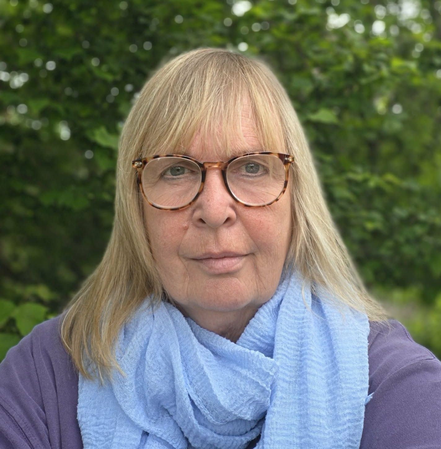 Kvinne med briller ser inn i kamera