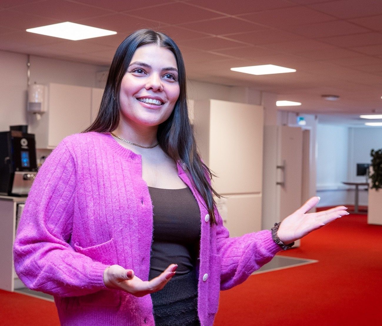 kvinne som gestikulerer og smiler mens hun snakker 