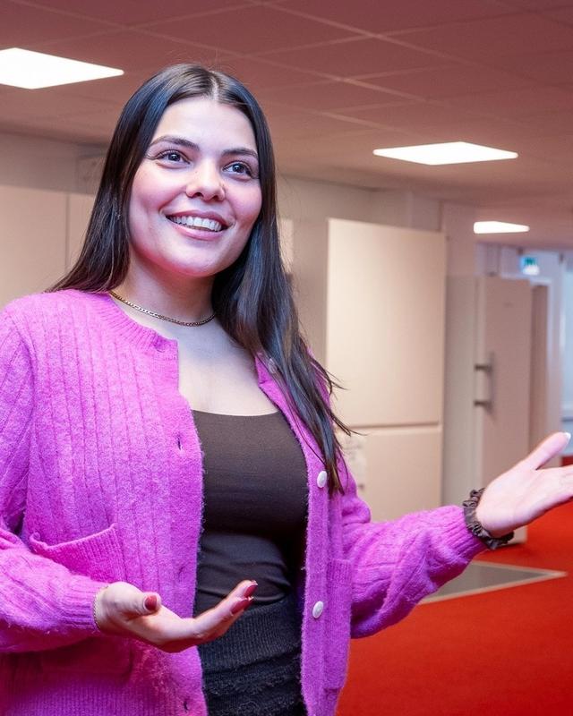kvinne som gestikulerer og smiler mens hun snakker