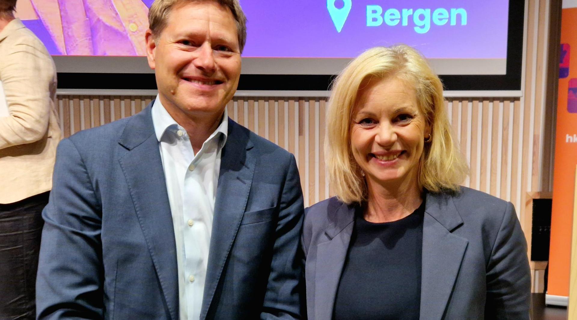 Mann og kvinne på scenen, ser i kamera