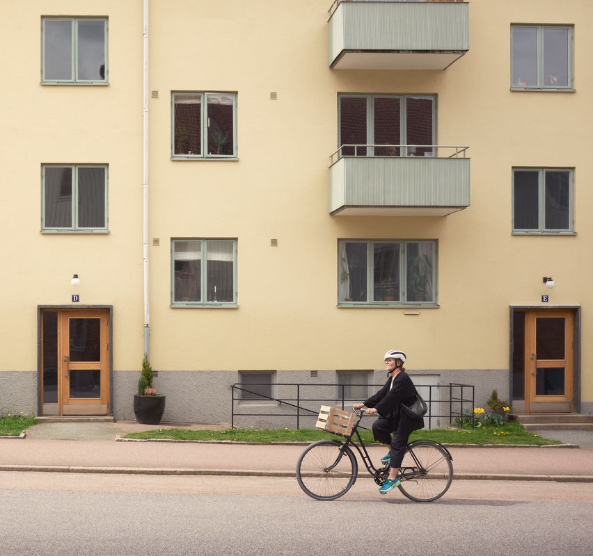 en dam som cyklar framför en lägenhet