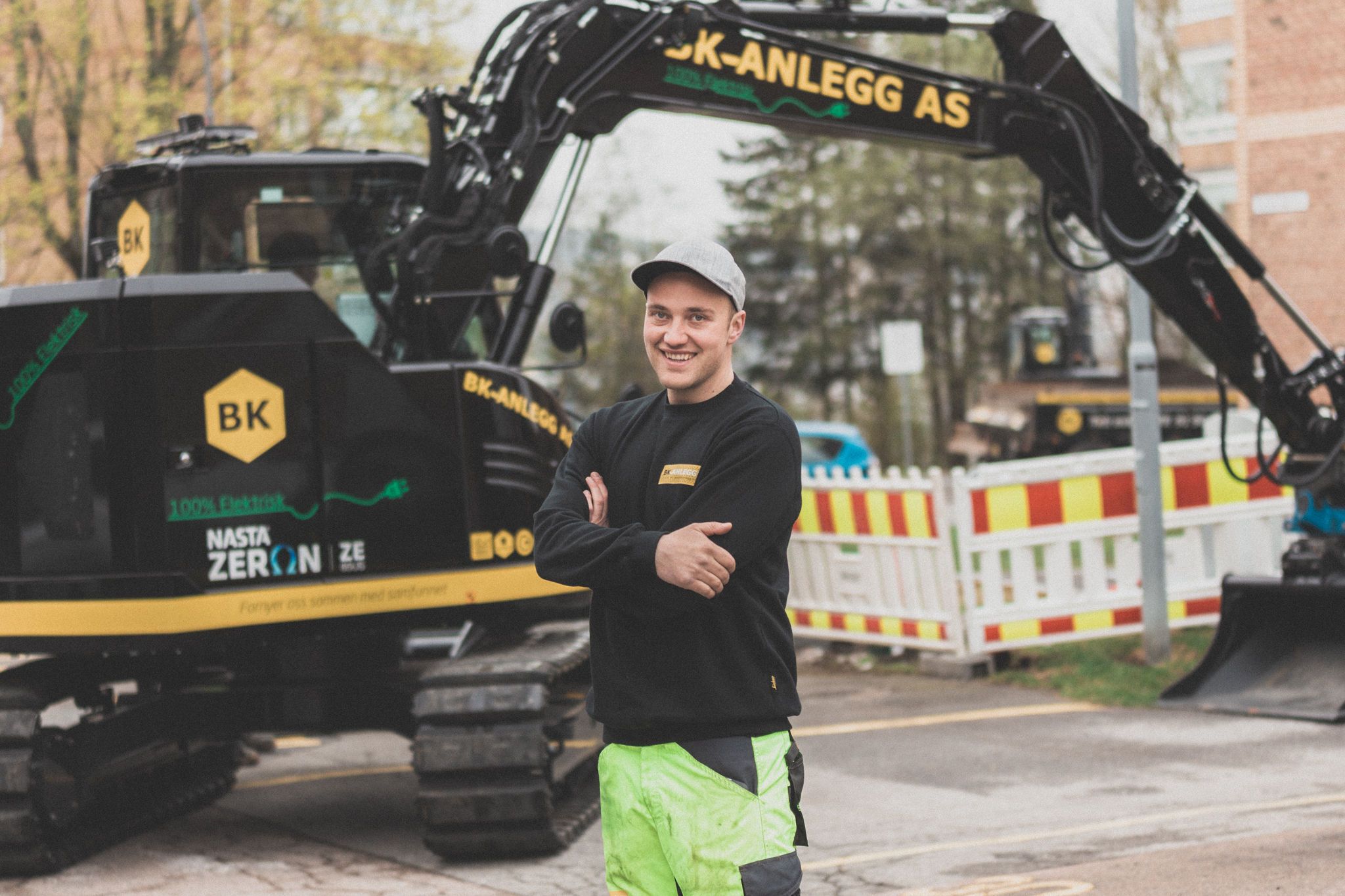 Byggnadsarbetare framför en grävmaskin