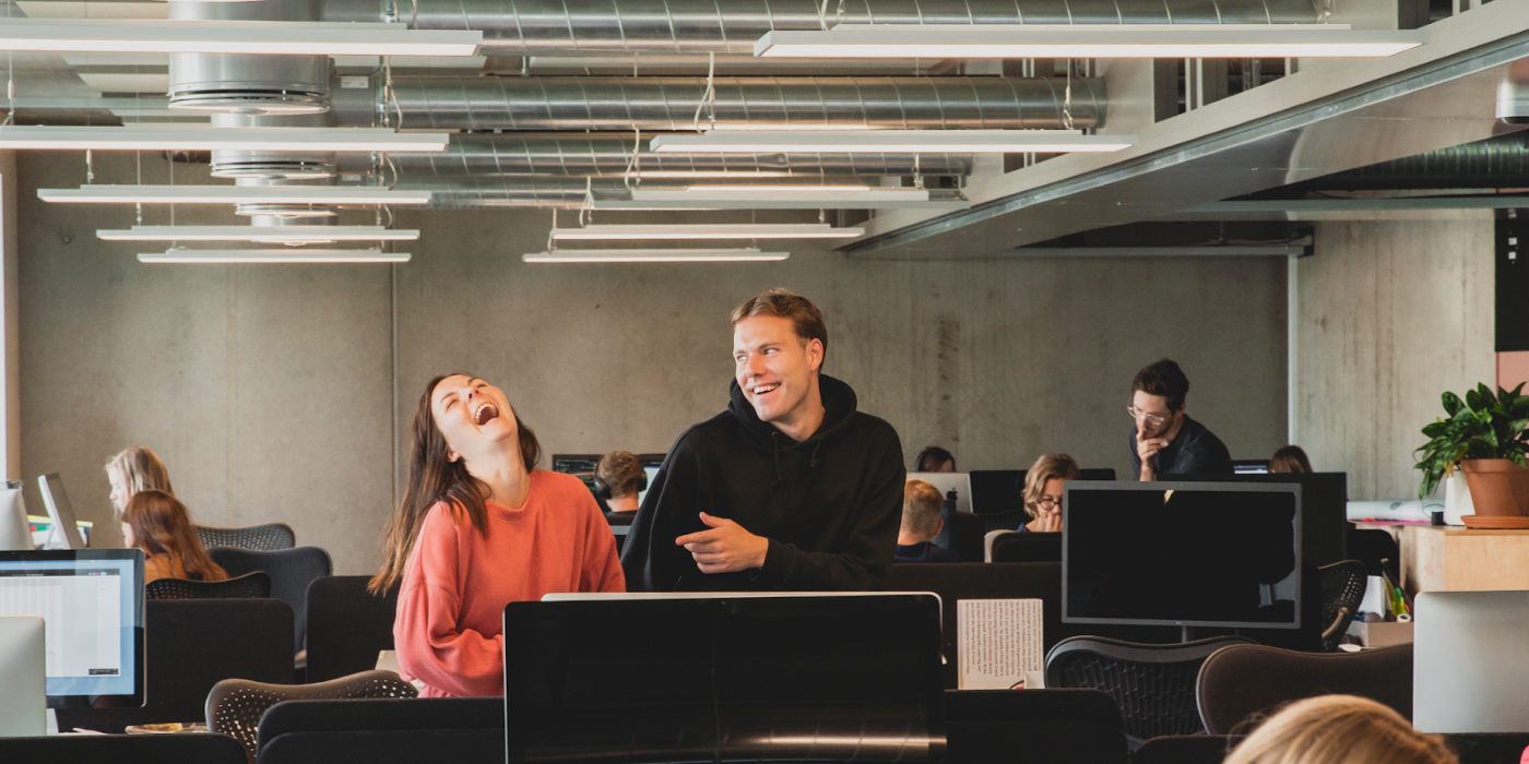 To Netlife-ansatte ler på kontoret