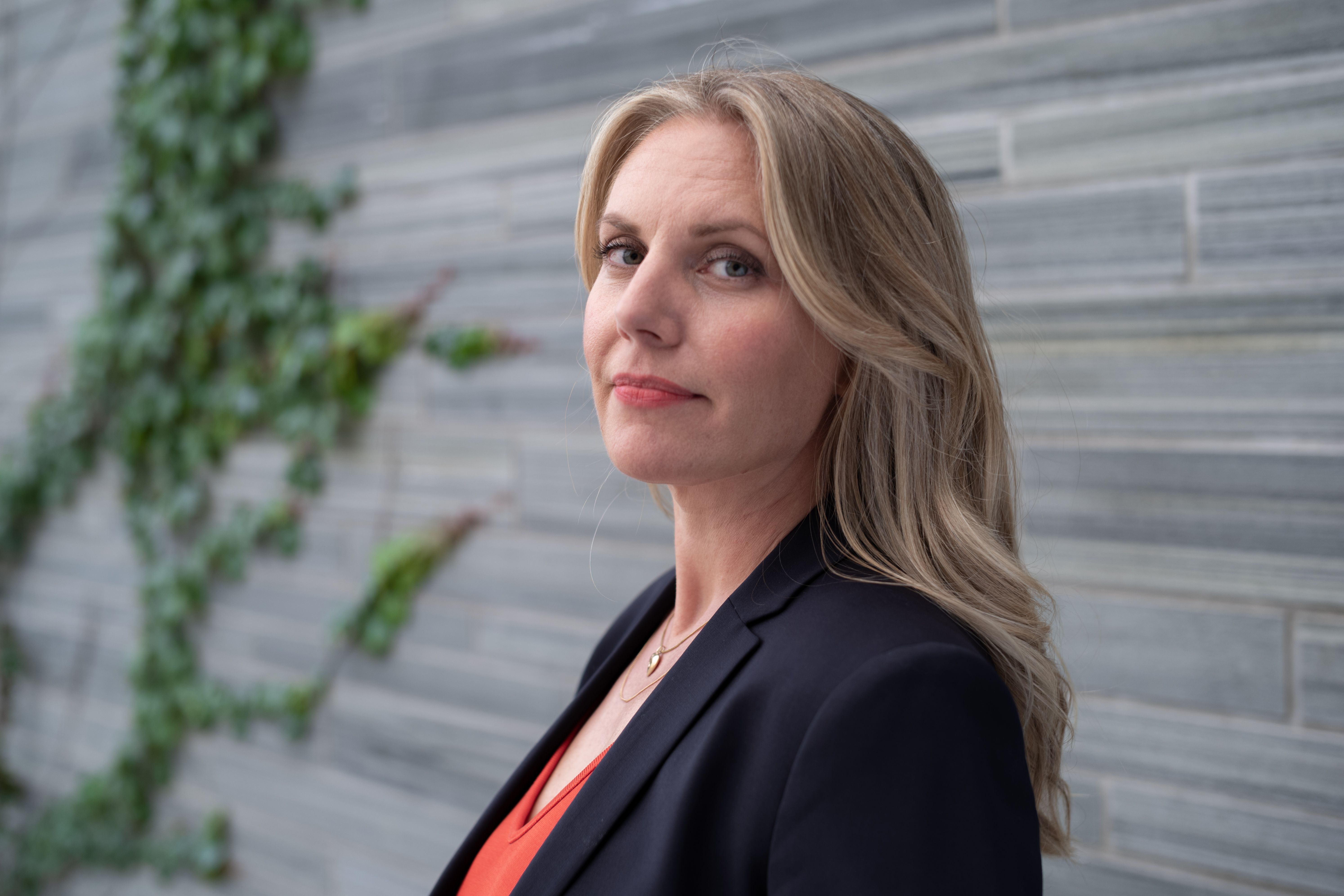 Kvinne med langt lyst hår og svart blazer.