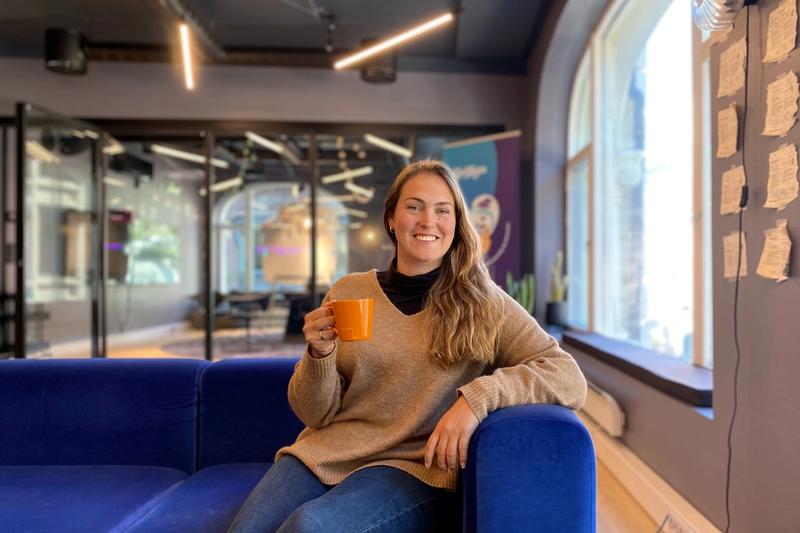 Helene sitter i sen sofa med en kaffekopp i hånda.