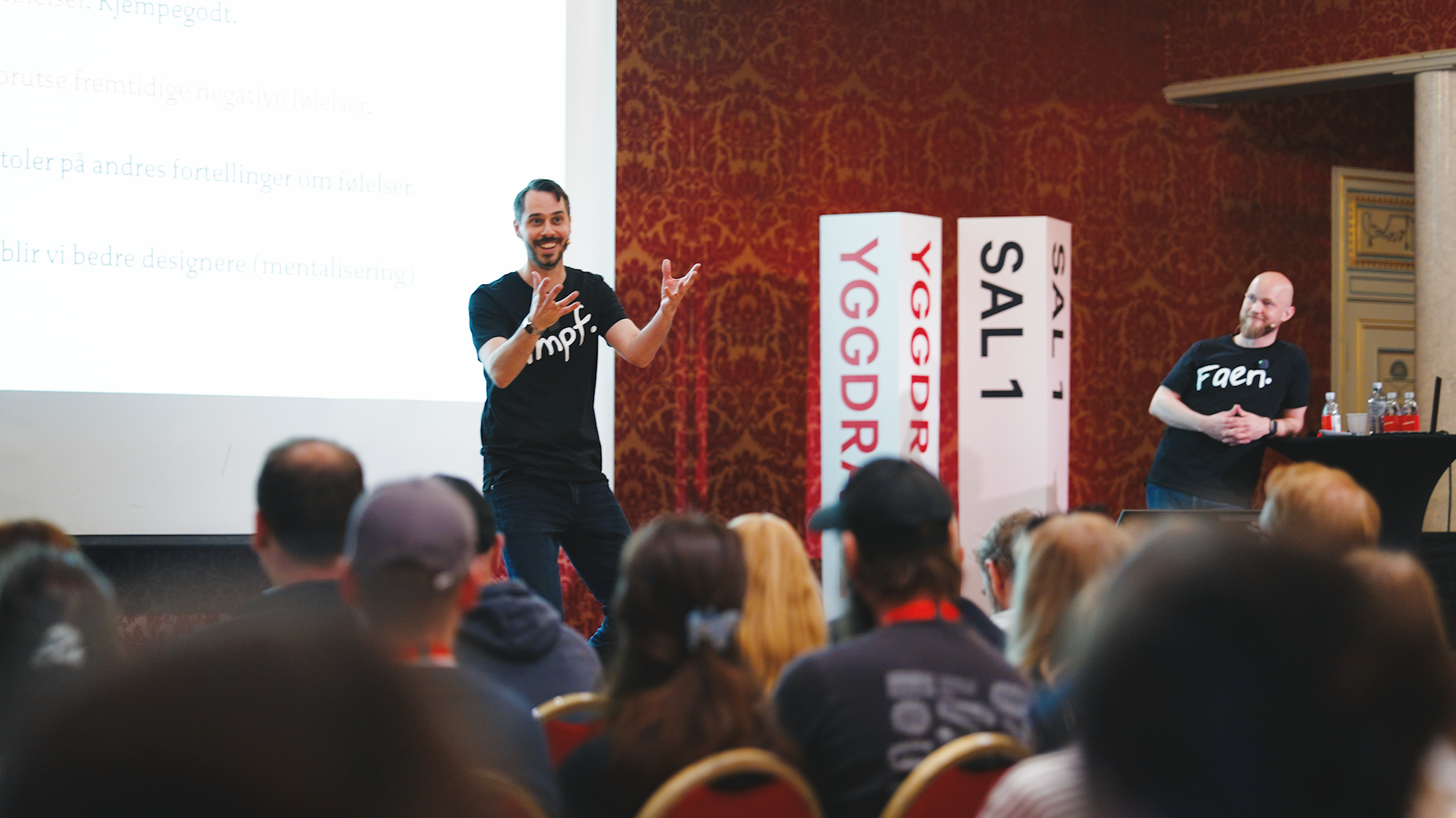 To menn står på scenen på Yggdrasil og snakker.