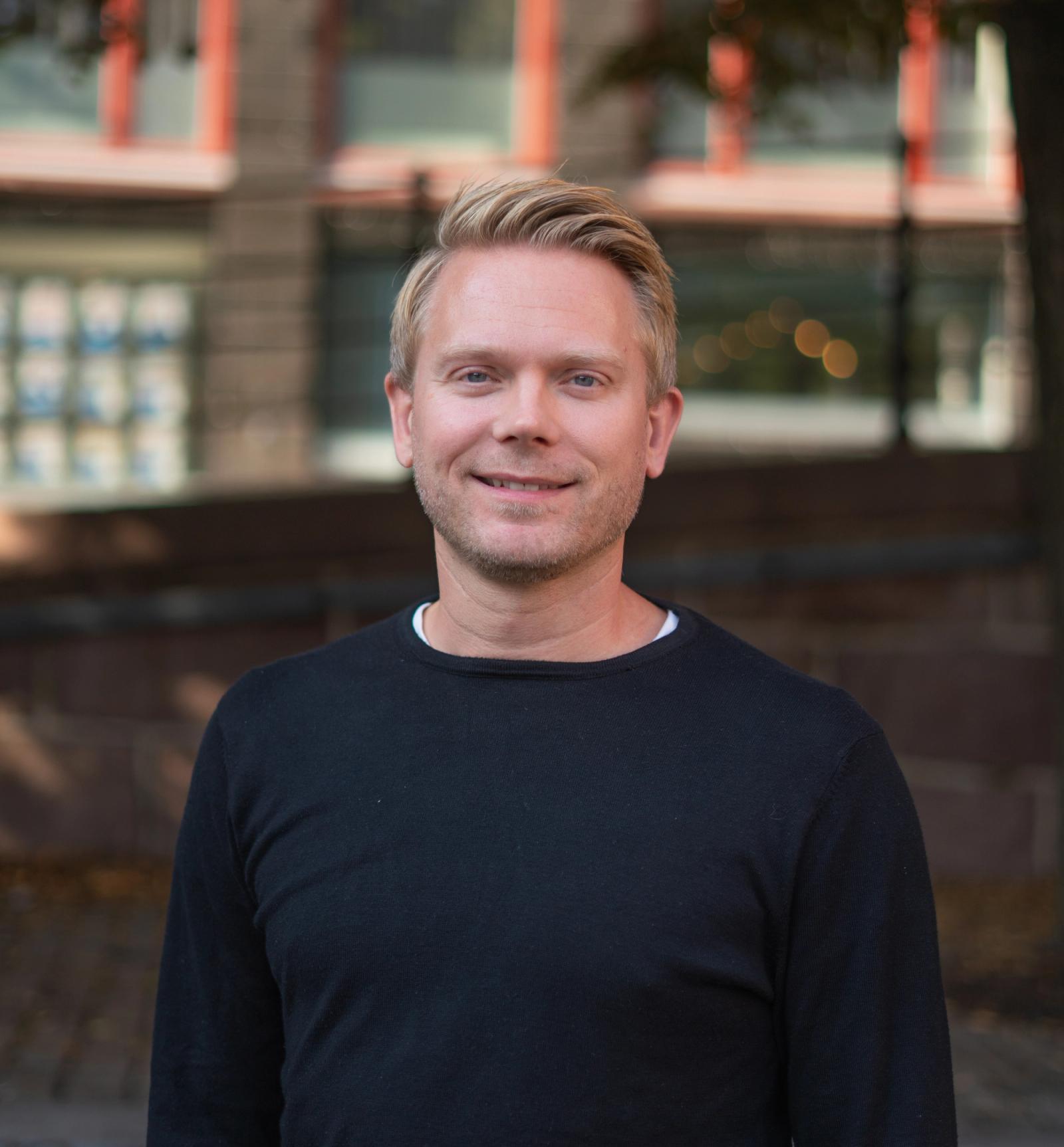 Mann med blondt hår og mørk genser.