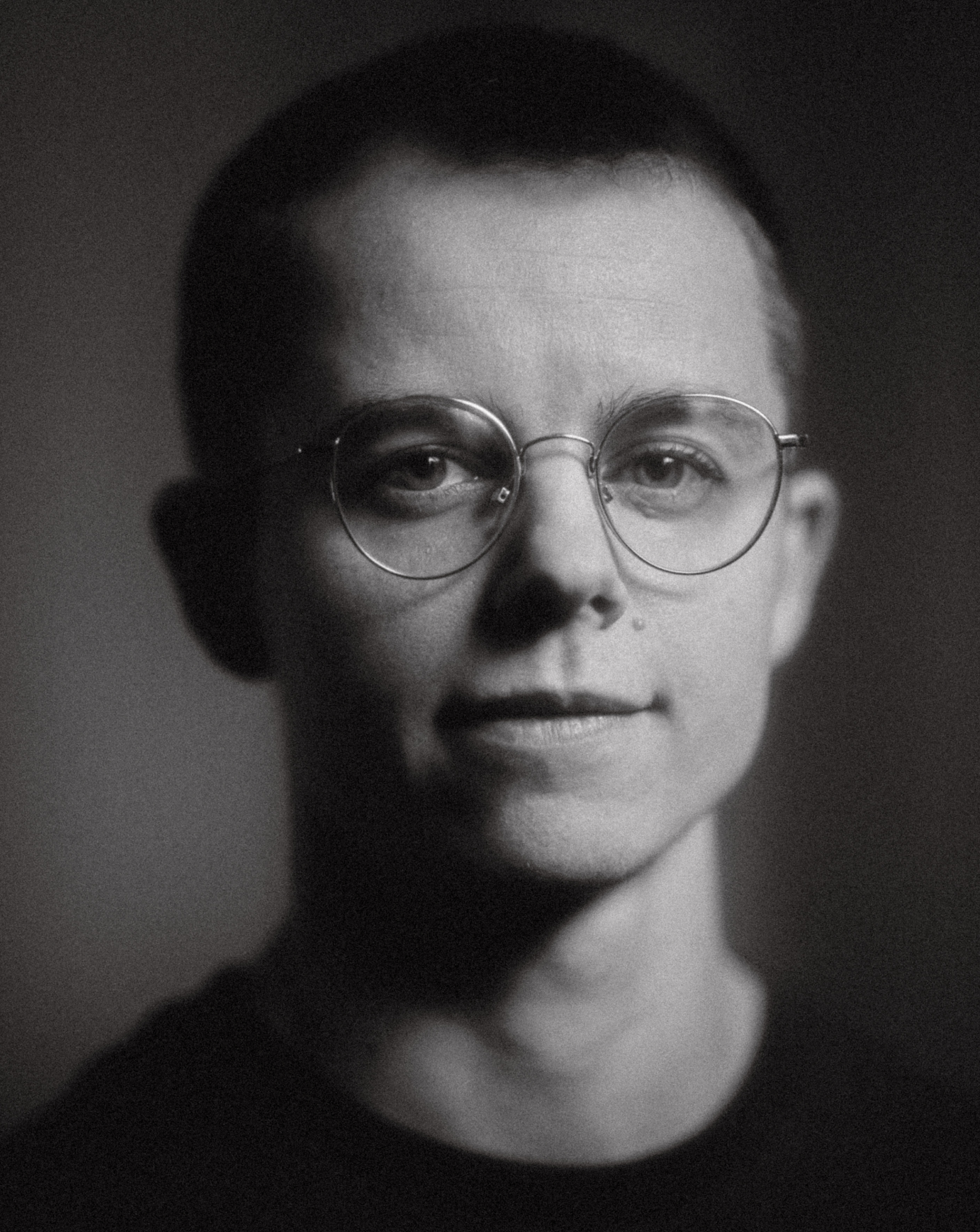 Svar-hvit portrettbilde av mann med kort hår og briller.