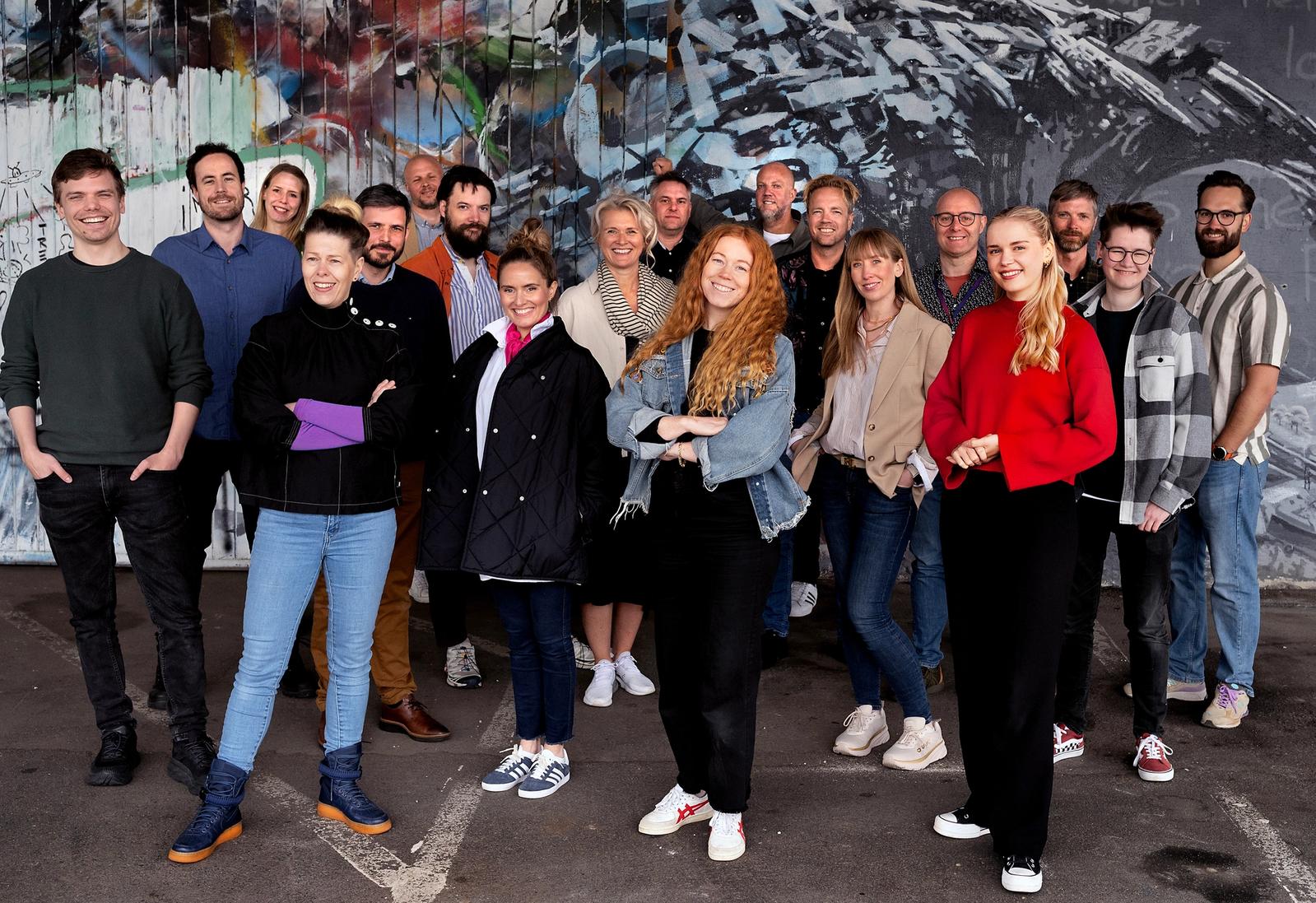 gruppebilde av these ways ansatte står samlet foran graffitivegg