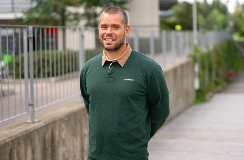 Mann med kort hår og skjegg smiler