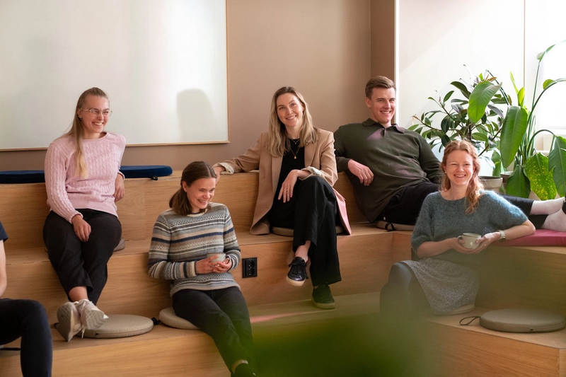 Fire kvinner og en mann sitter i trapper