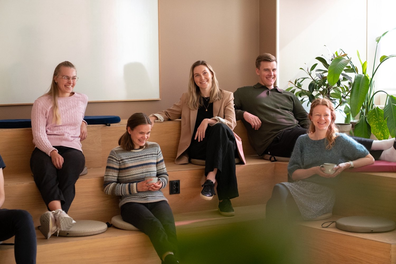 Fire kvinner og en mann sitter i trapper