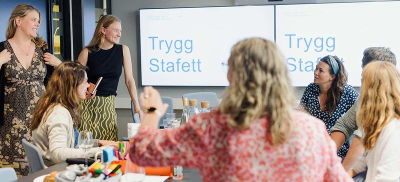 Kvinner sitter rundt et bord på et møterom