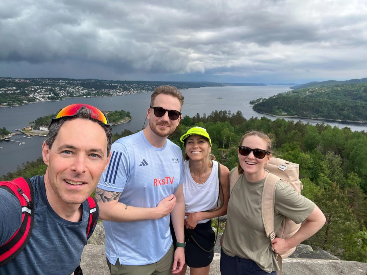 Fire mennesker står på et fjell