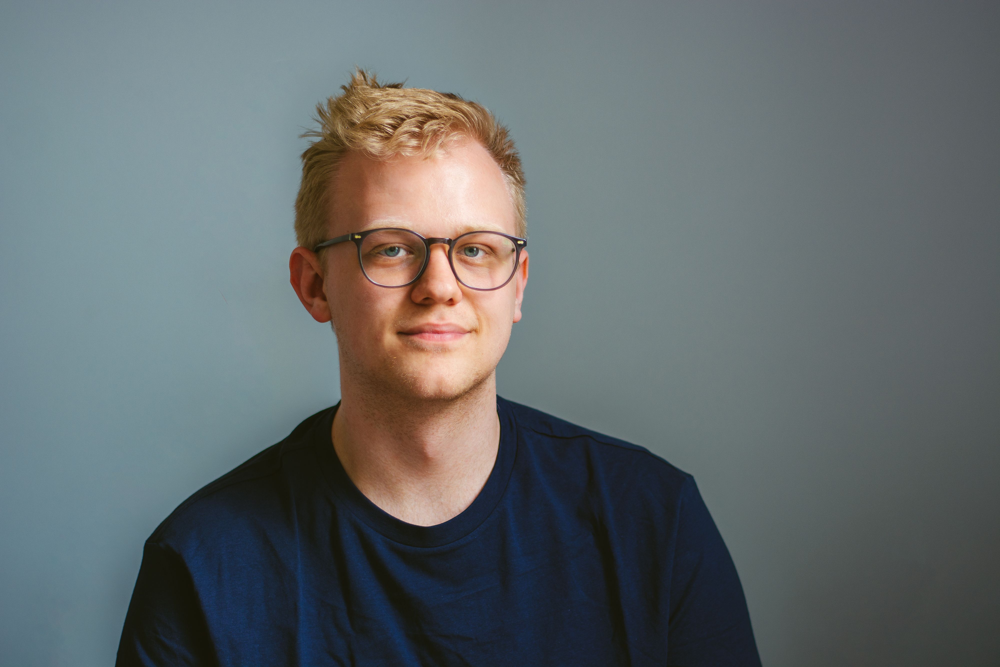 Klassisk portrett av mann med lyst kort hår og briller 