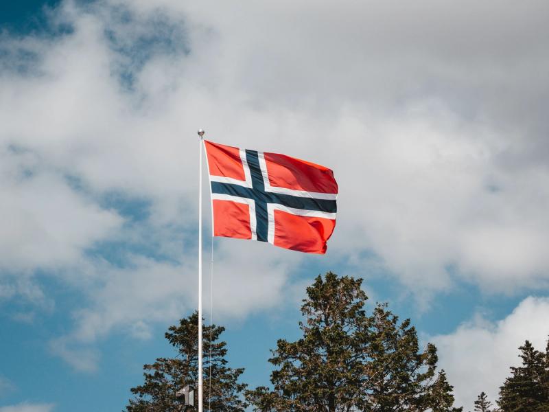 Norsk flagg foran blå himmel