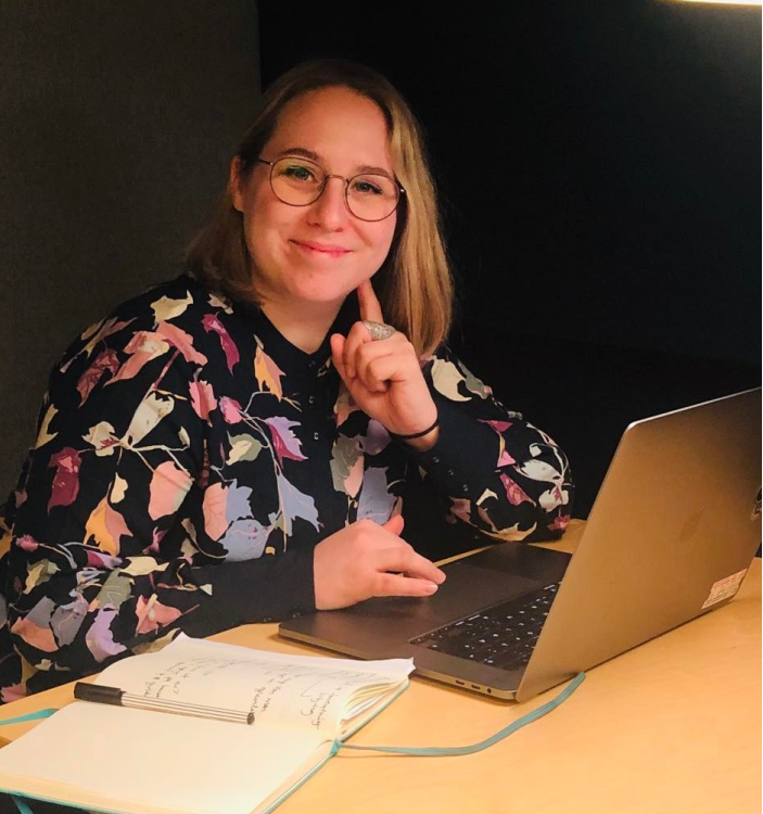 Maria sitter ved laptopen og notatboken.