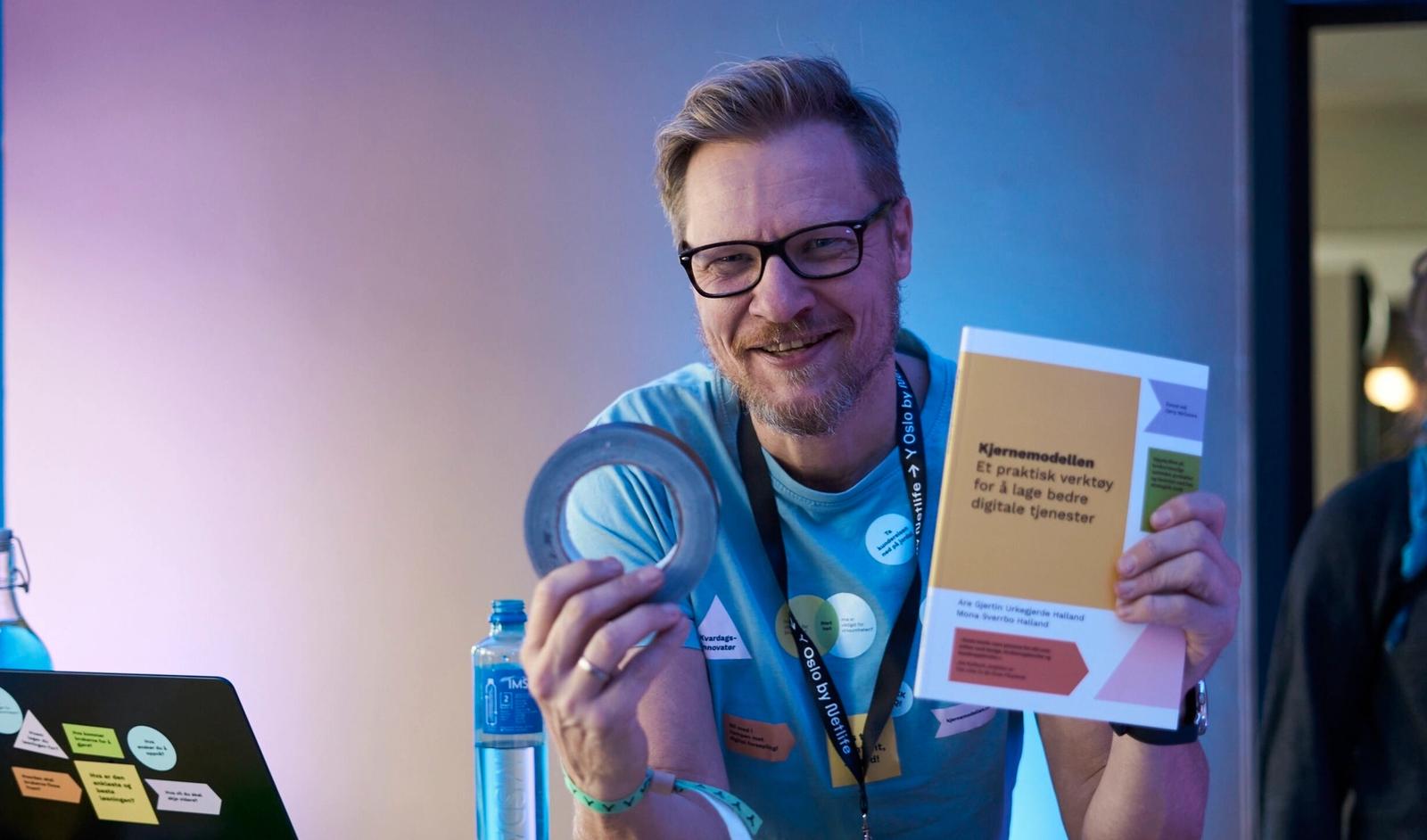 Kjernekaren med boka si i den ene hånden og gaffateip i den andre.