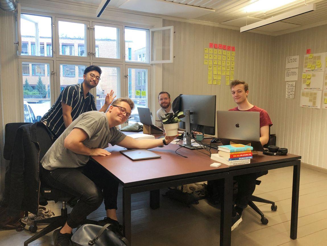 Fire unge menn på et kontor.