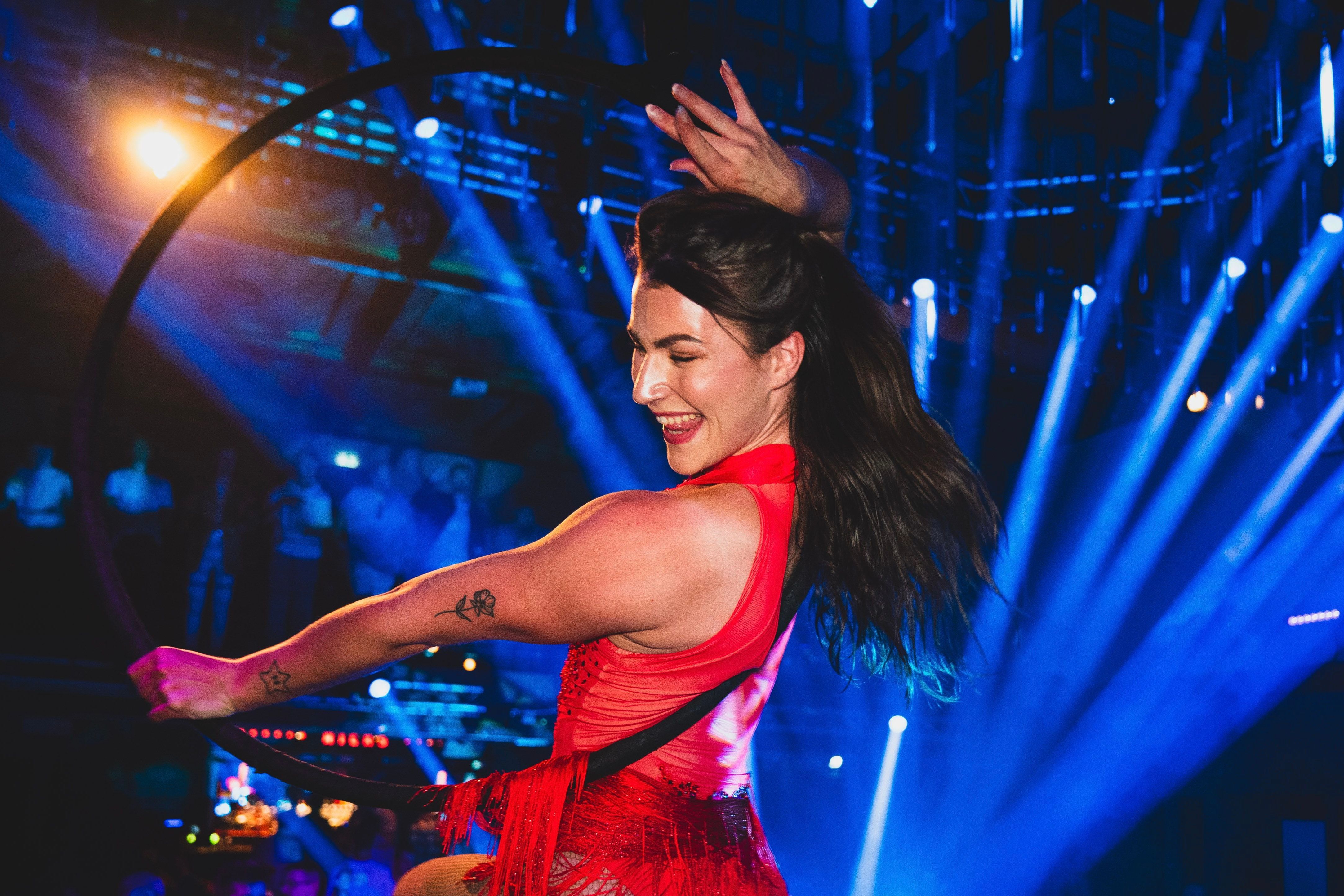 Smilende og energisk dame gjør seg klar for å gå henge fra taket i en ring.