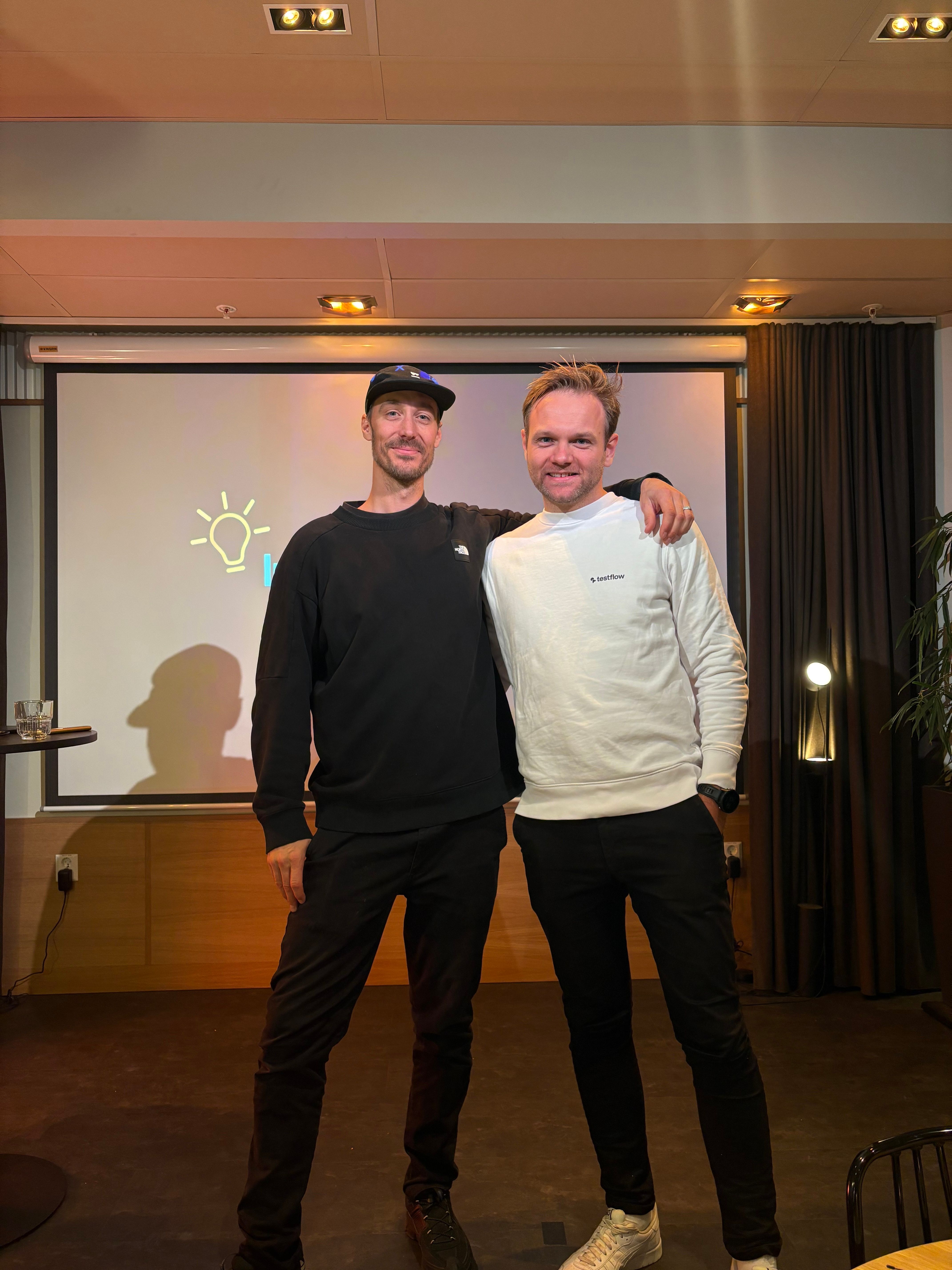 To menn står på scenen, med armene rundt hverandre.