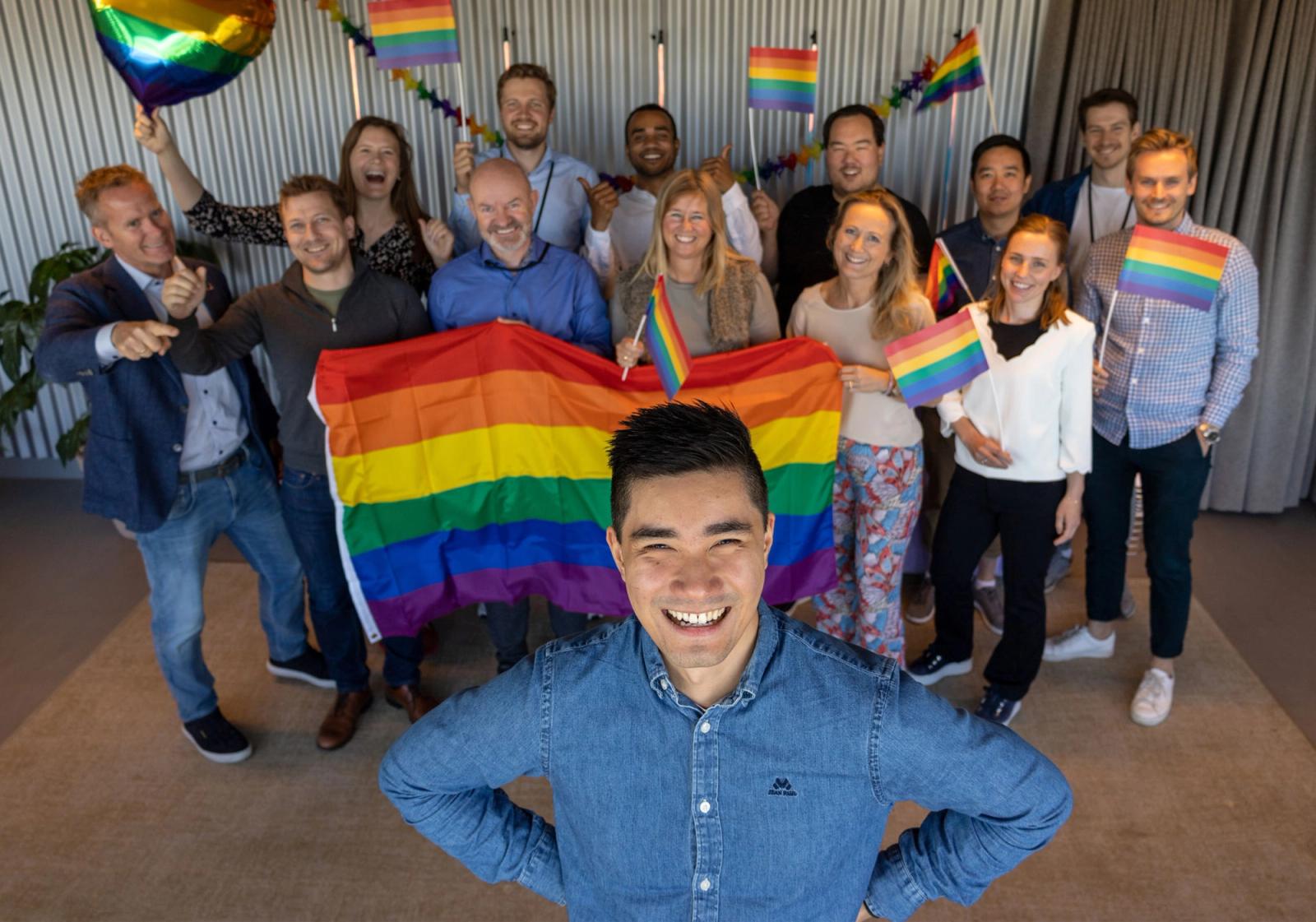 En gjeng ansatte i Webstep står baregnbueflagg. 📸: Webstep