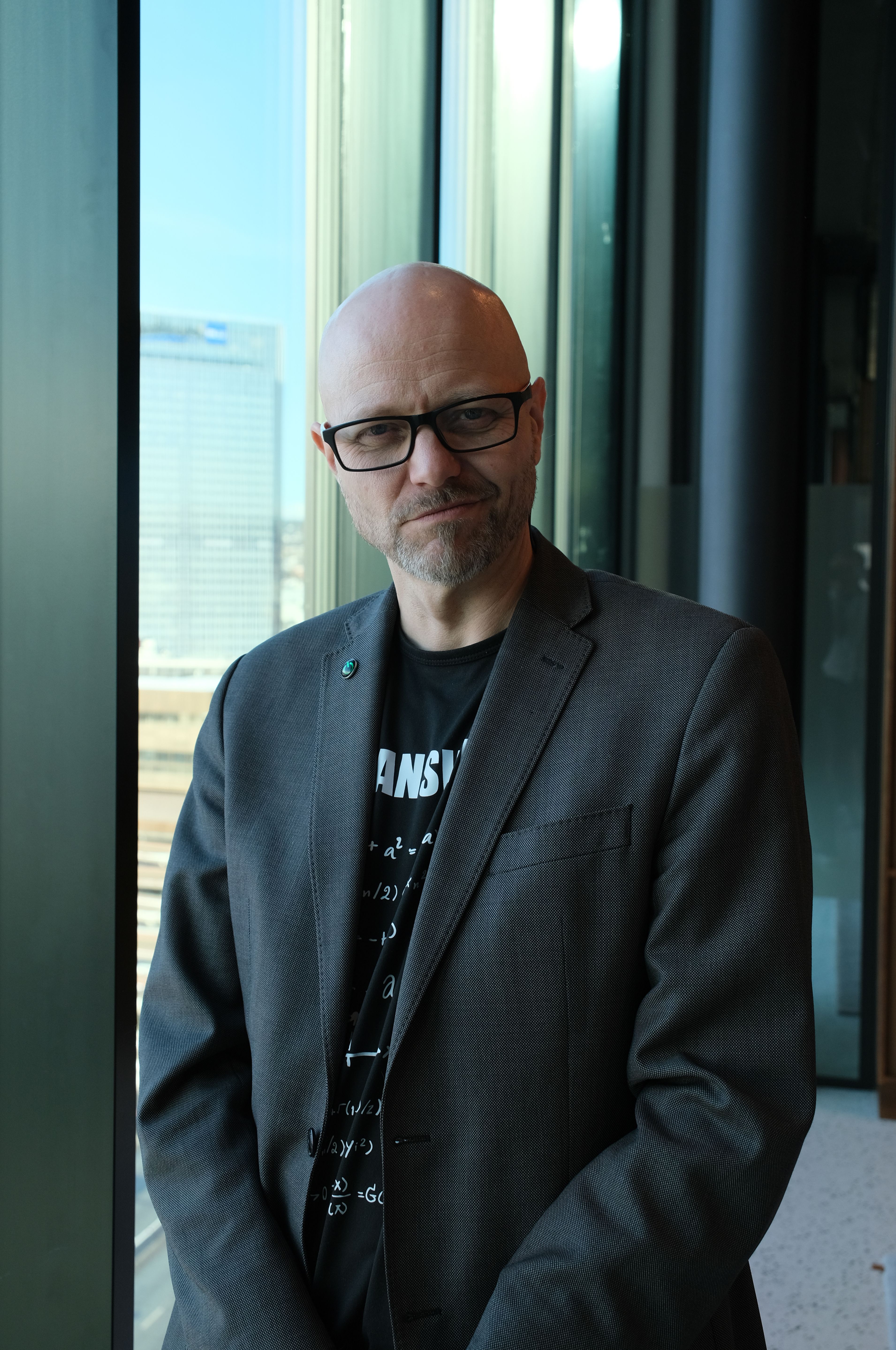 Mann i blazer står inne i et bygg