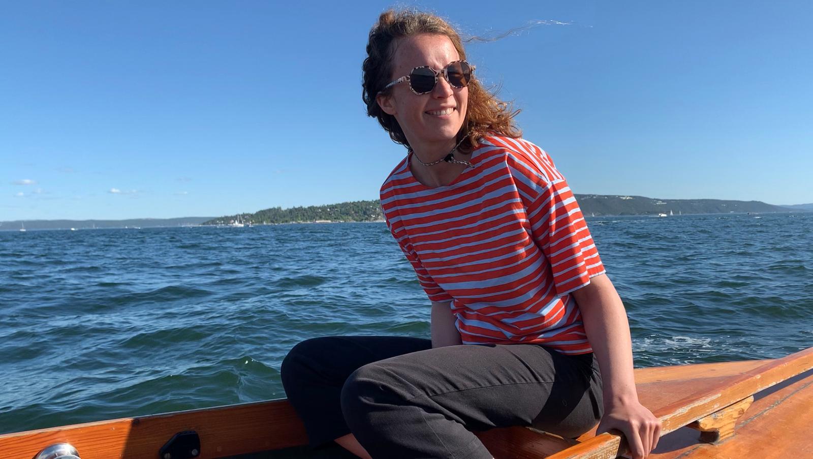 Dame i båt på sjøen en sommersdag.