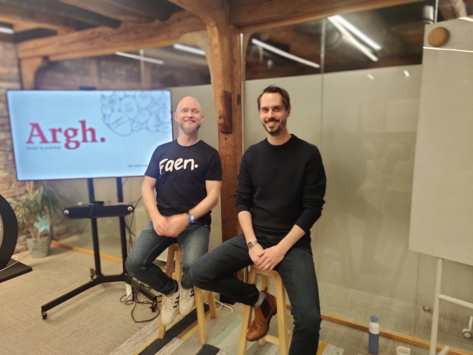 To menn med en skjerm hvor det står Argh.