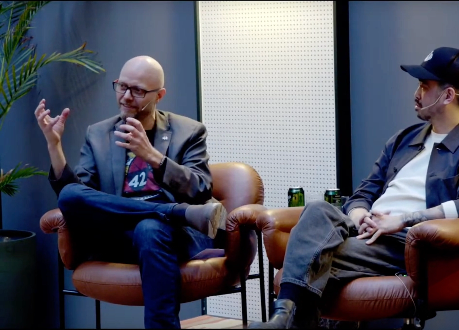 To menn sitter i stoler og snakker