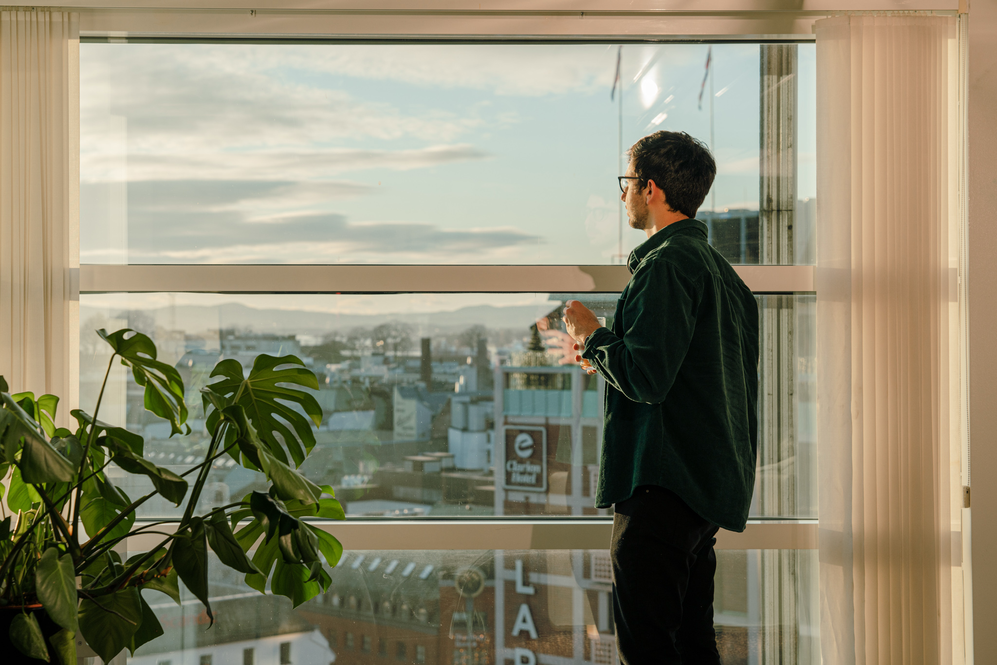 Mann ser ut av et vindu.