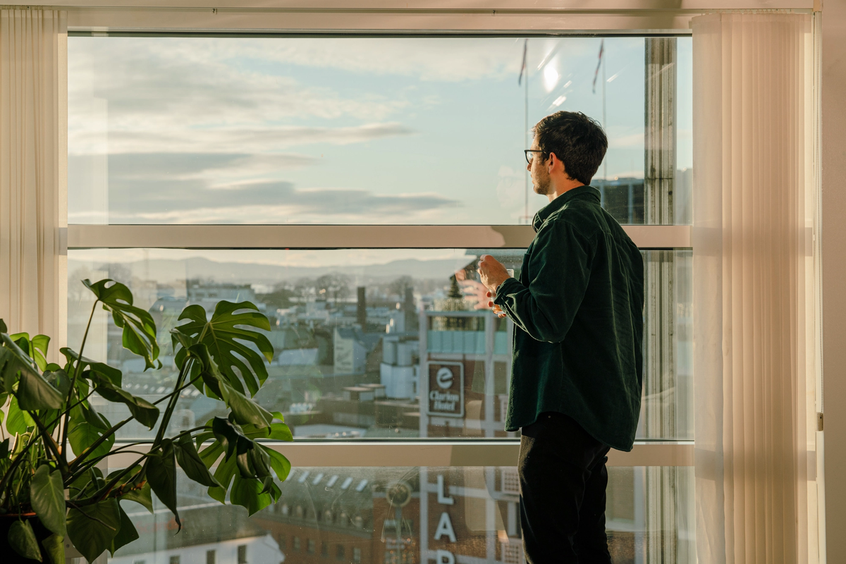 Mann ser ut av et vindu.