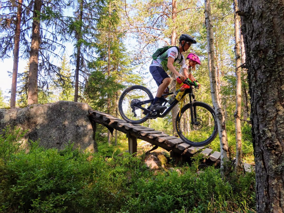 Anders og datteren på sykkel i skogen.