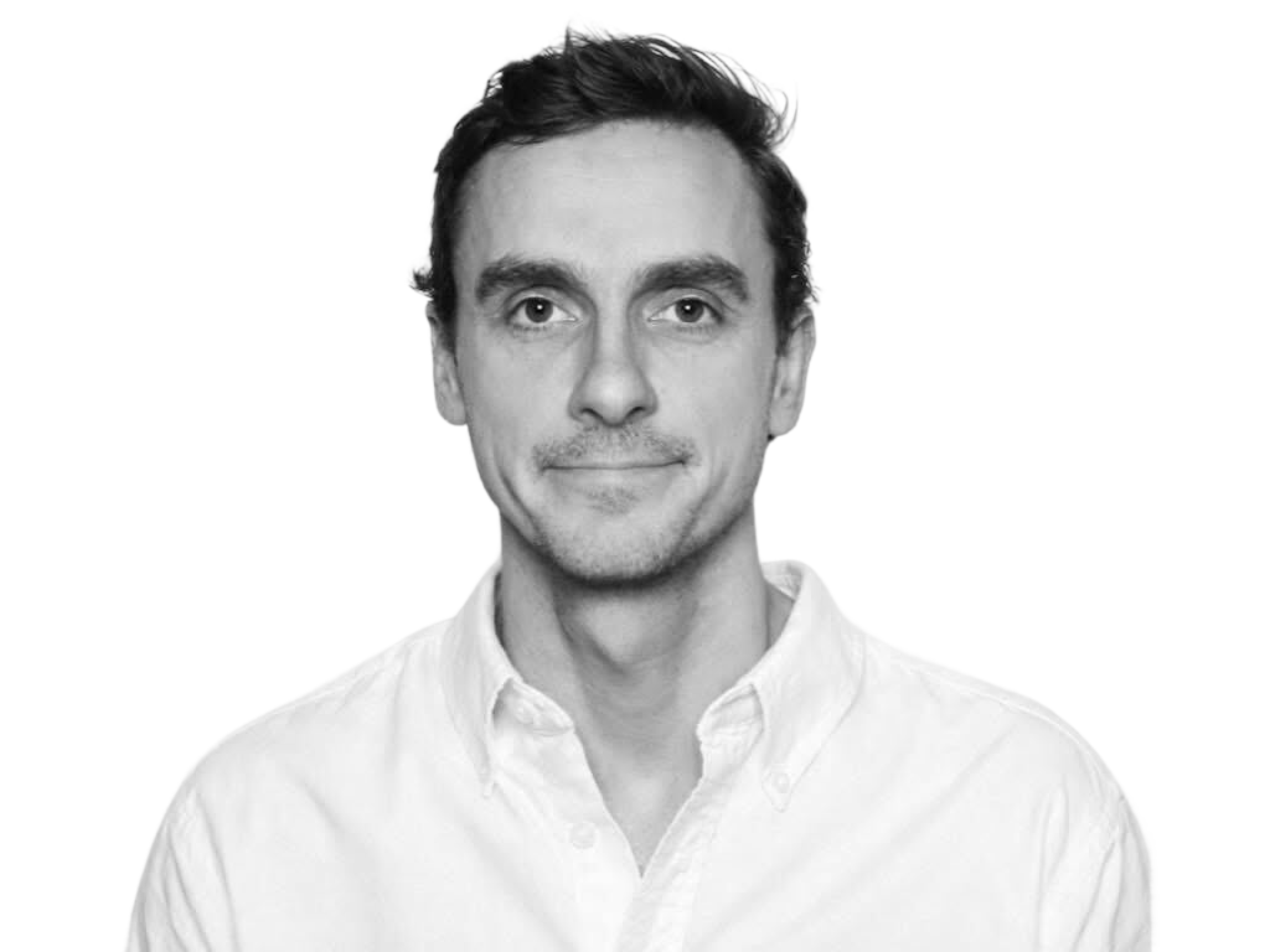 Svart hvitt bilde av mann med hvit skjorte og kort hår. Han har het nøytralt ansiktsutrykk.