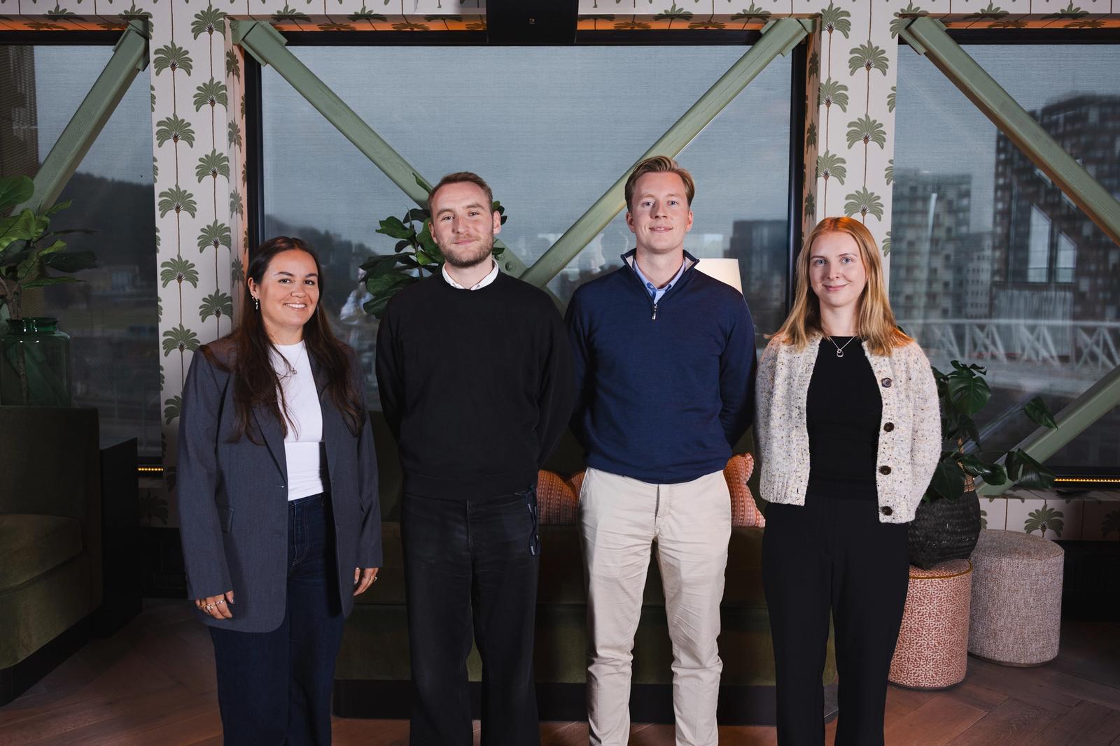 To kvinner og to menn poserer utendørs.