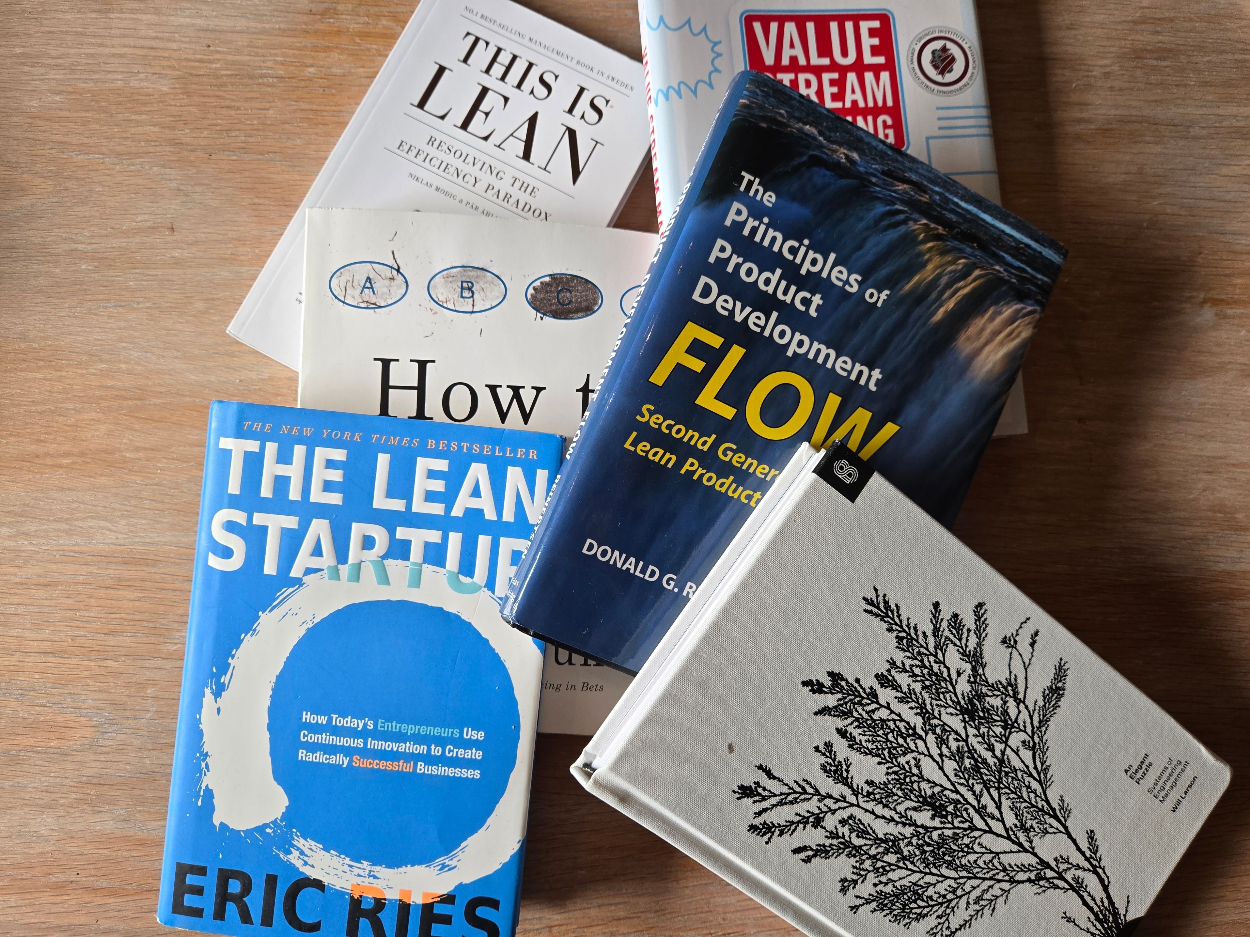 En haug med bøker ligger på et bord.