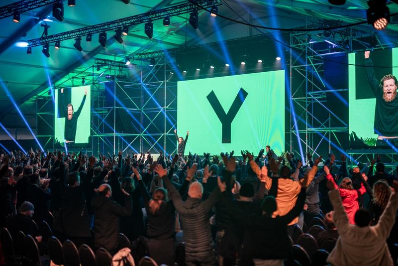 Bilde fra salen på Y-konferansen, masse folk med hendene i været