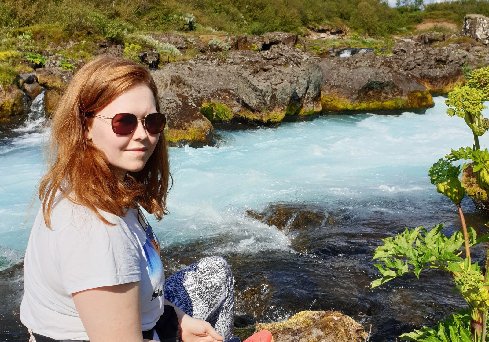 María Maurstad Ævarsdóttir sitter ute ved en bekk.