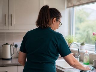An Oakma carer wiping down the kitchen worktop during a home help visit
