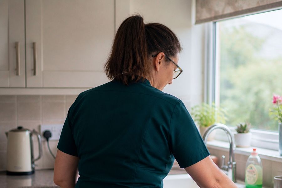 An Oakma carer wiping down the kitchen worktop during a home help visit