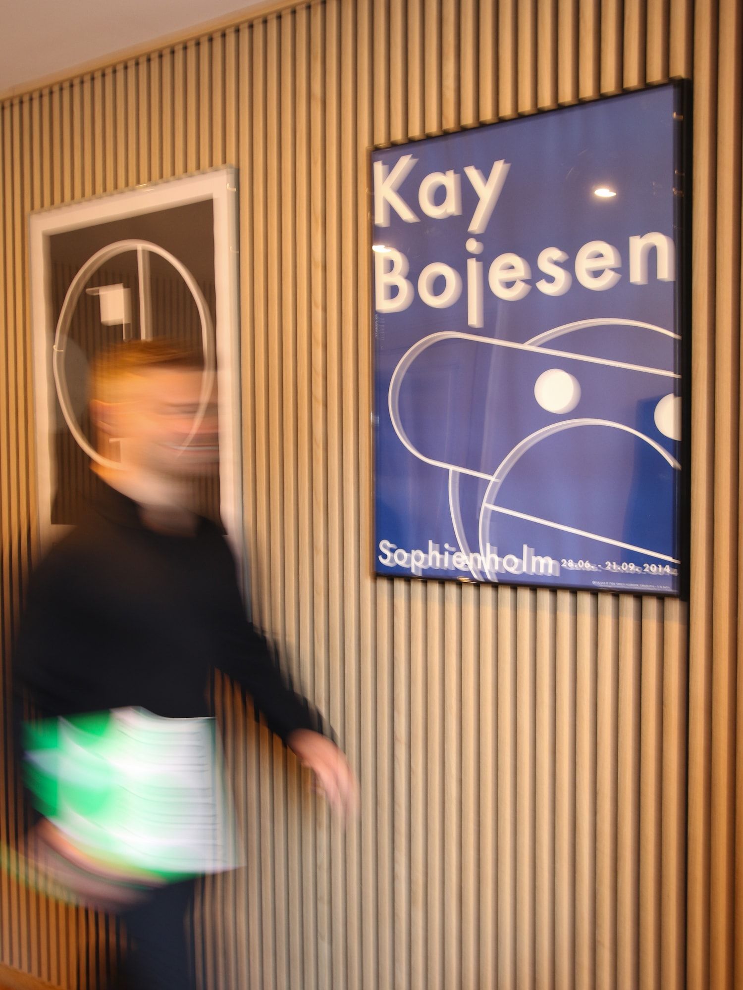 Rasmus walking past a Kay Bojesen poster in the Copenhagen office
