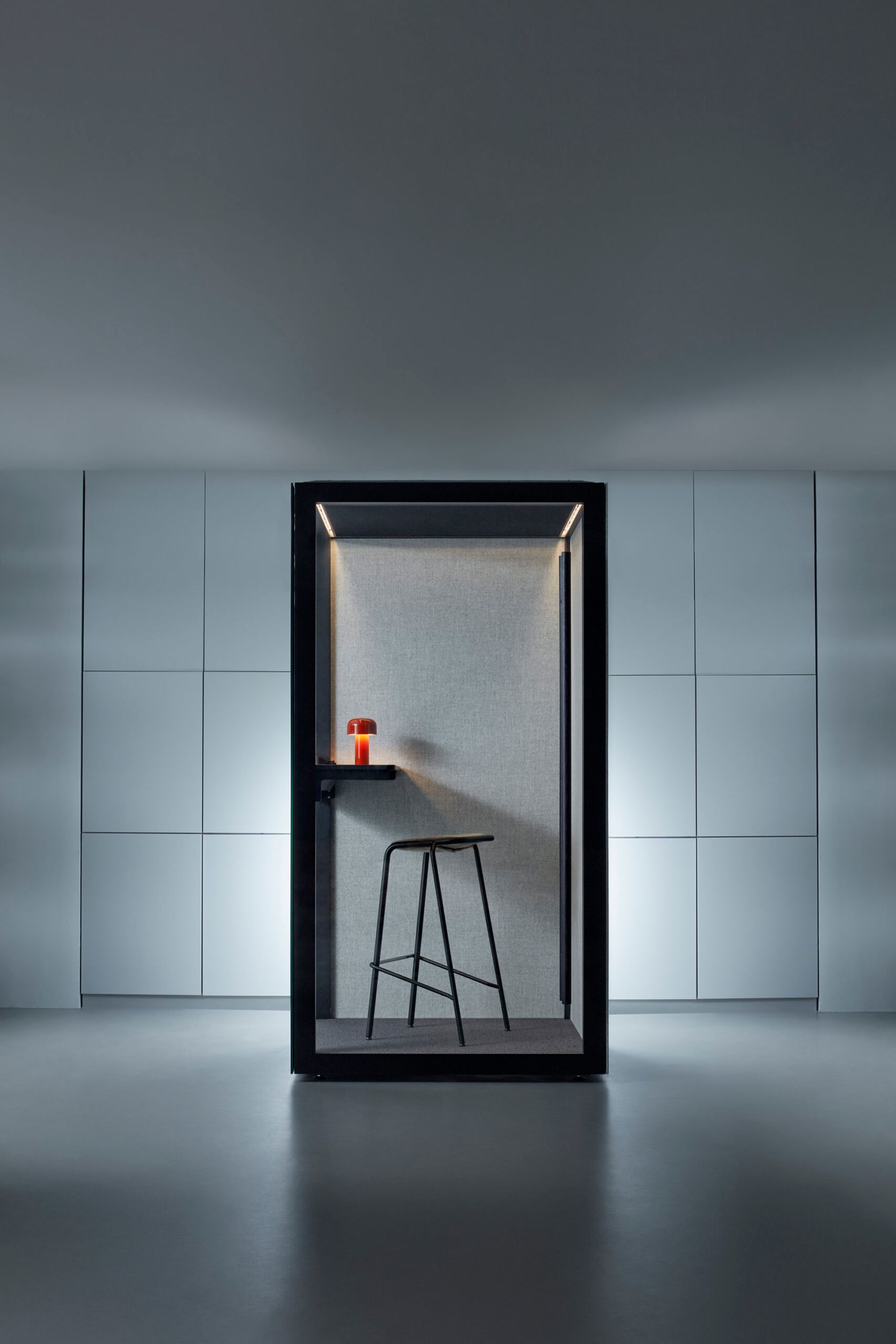 Small dark Zen Pod with stool and red lamp inside