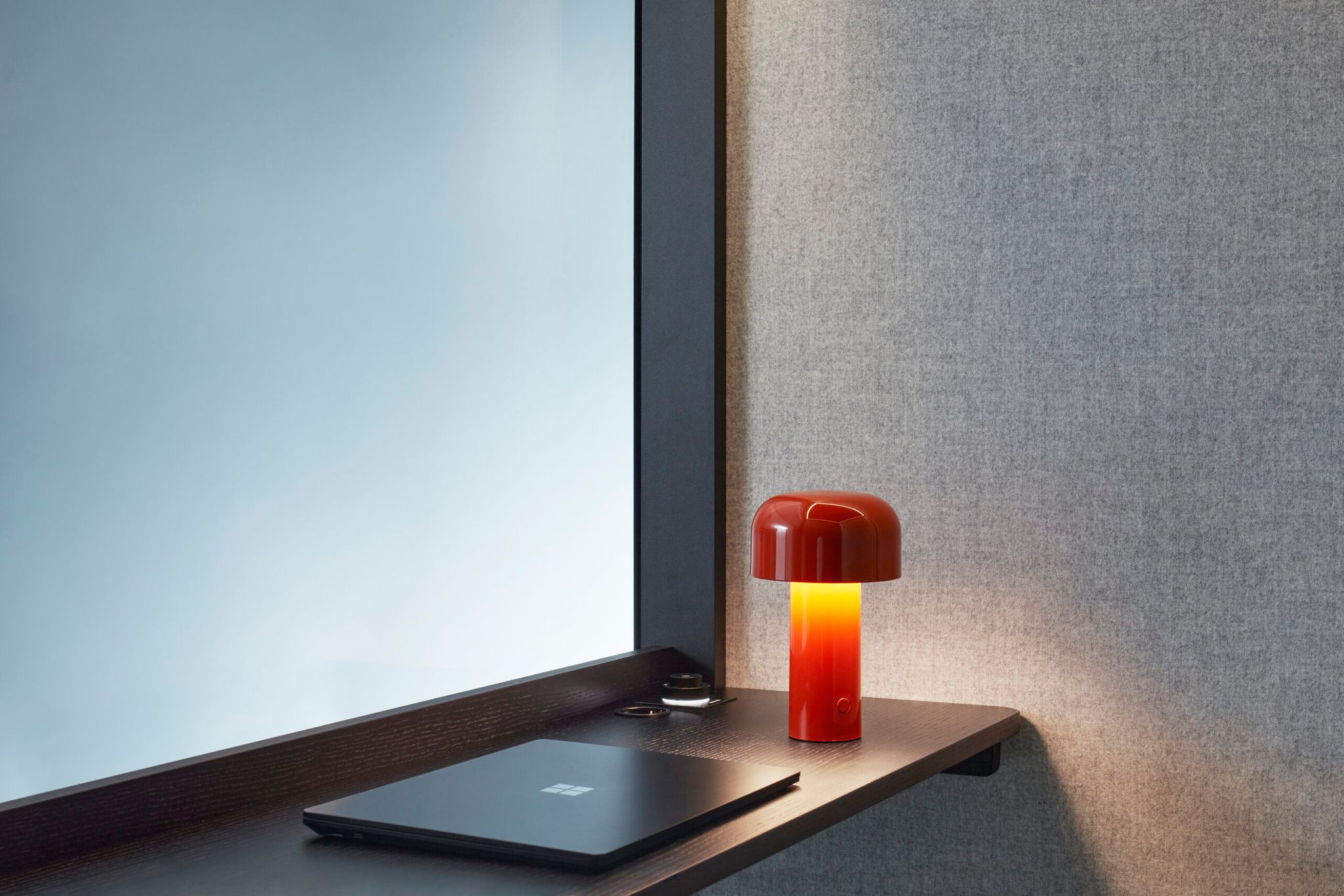 Small dark Zen Pod workspace with laptop and red lamp