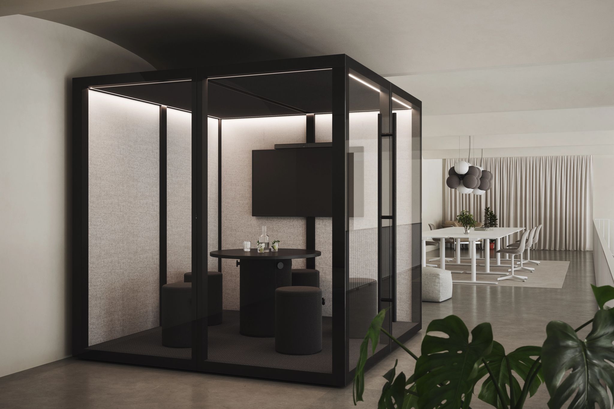 Zen Pod with black frame, round table, stools, and wall-mounted screen in a modern office space.
