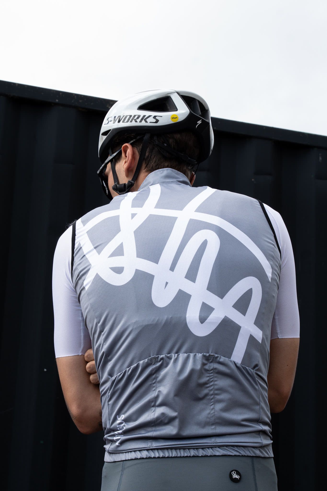 Cyclist from behind wearing a grey script jersey