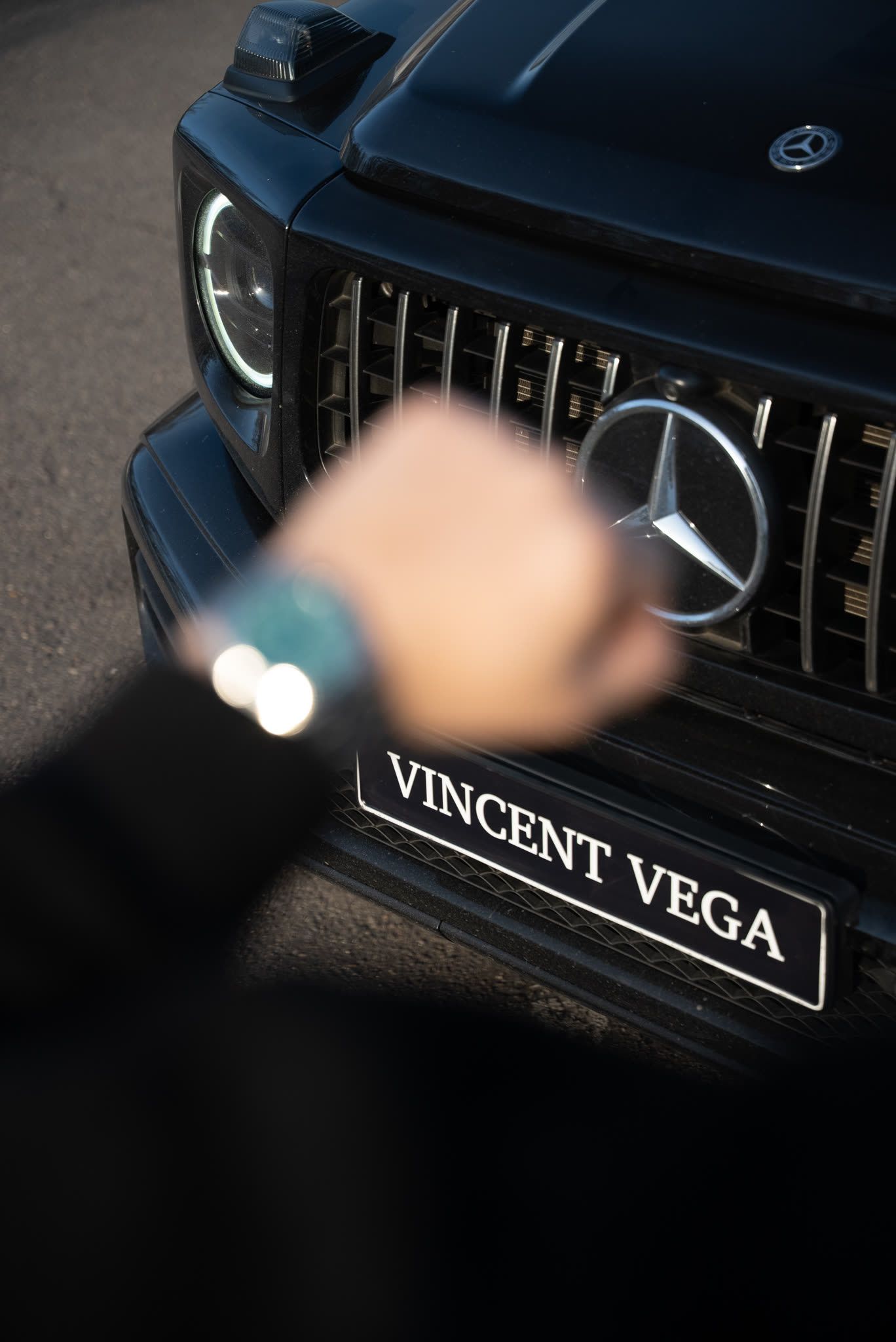 Mercedes G-Class grille with a wristwatch in the foreground