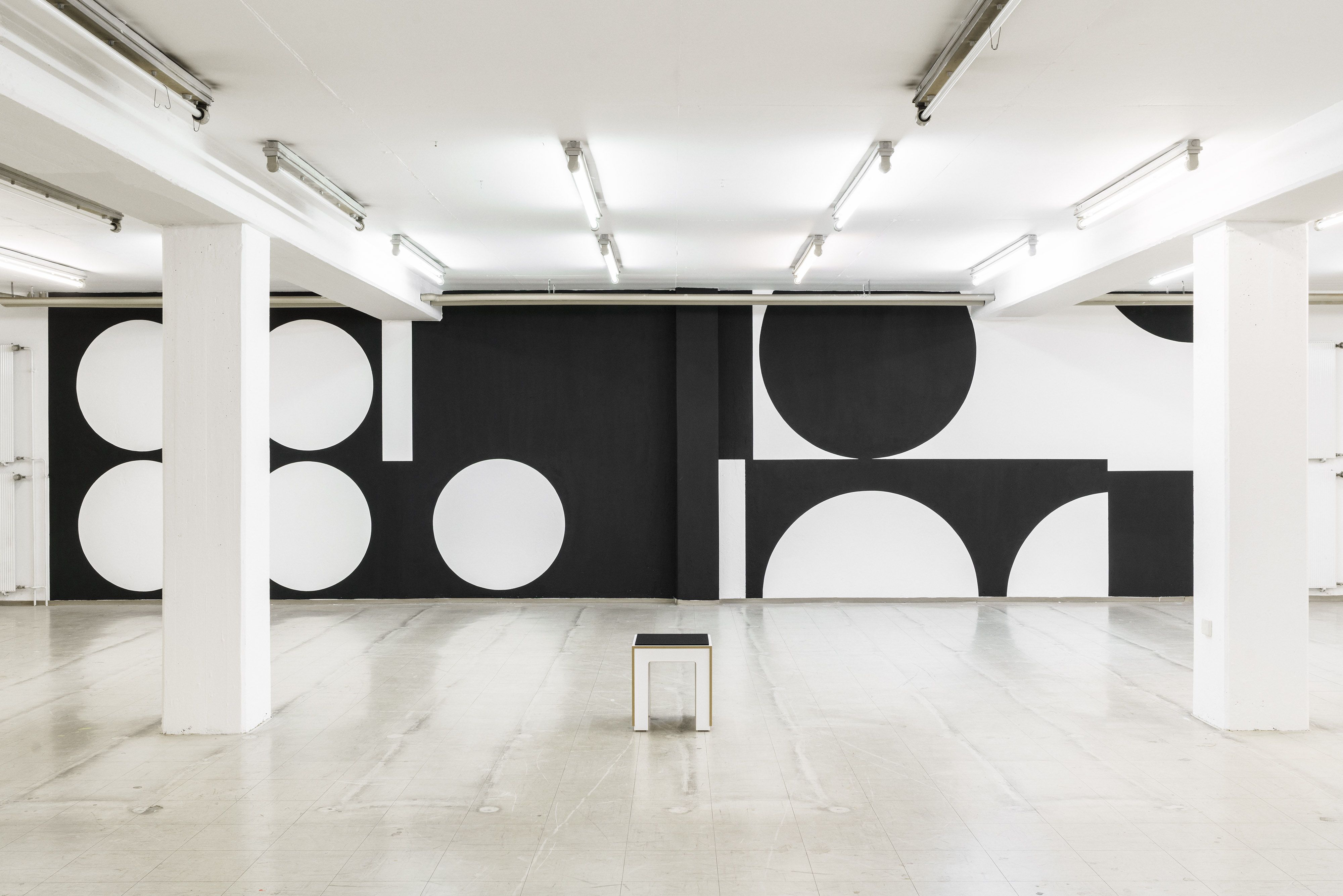 Solo exhibition wall graphic by Manuel Lorenz, black geometric shapes on white wall, 2.6 × 22 m