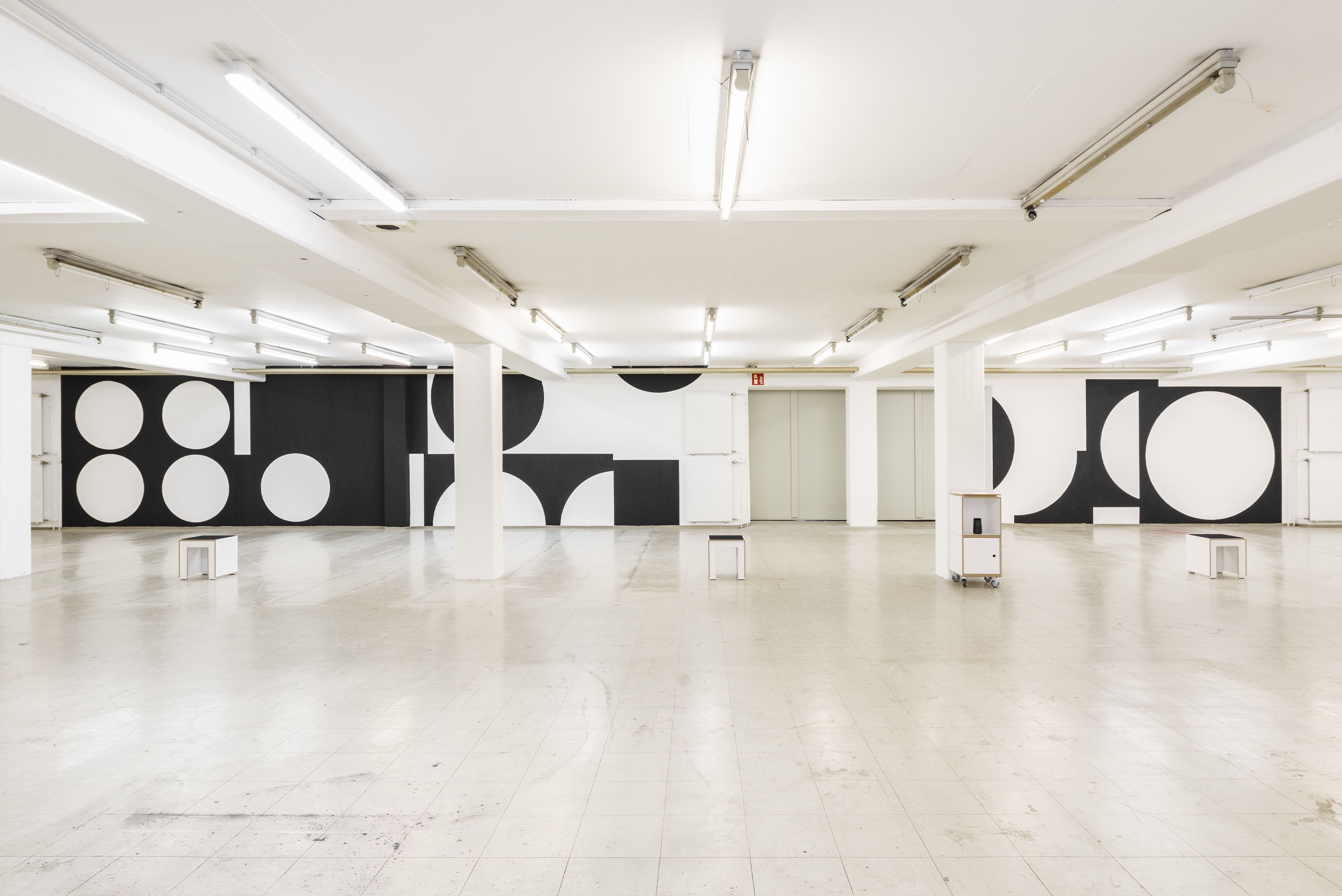 Solo exhibition wall graphic by Manuel Lorenz, black geometric shapes on white wall, 2.6 × 22 m