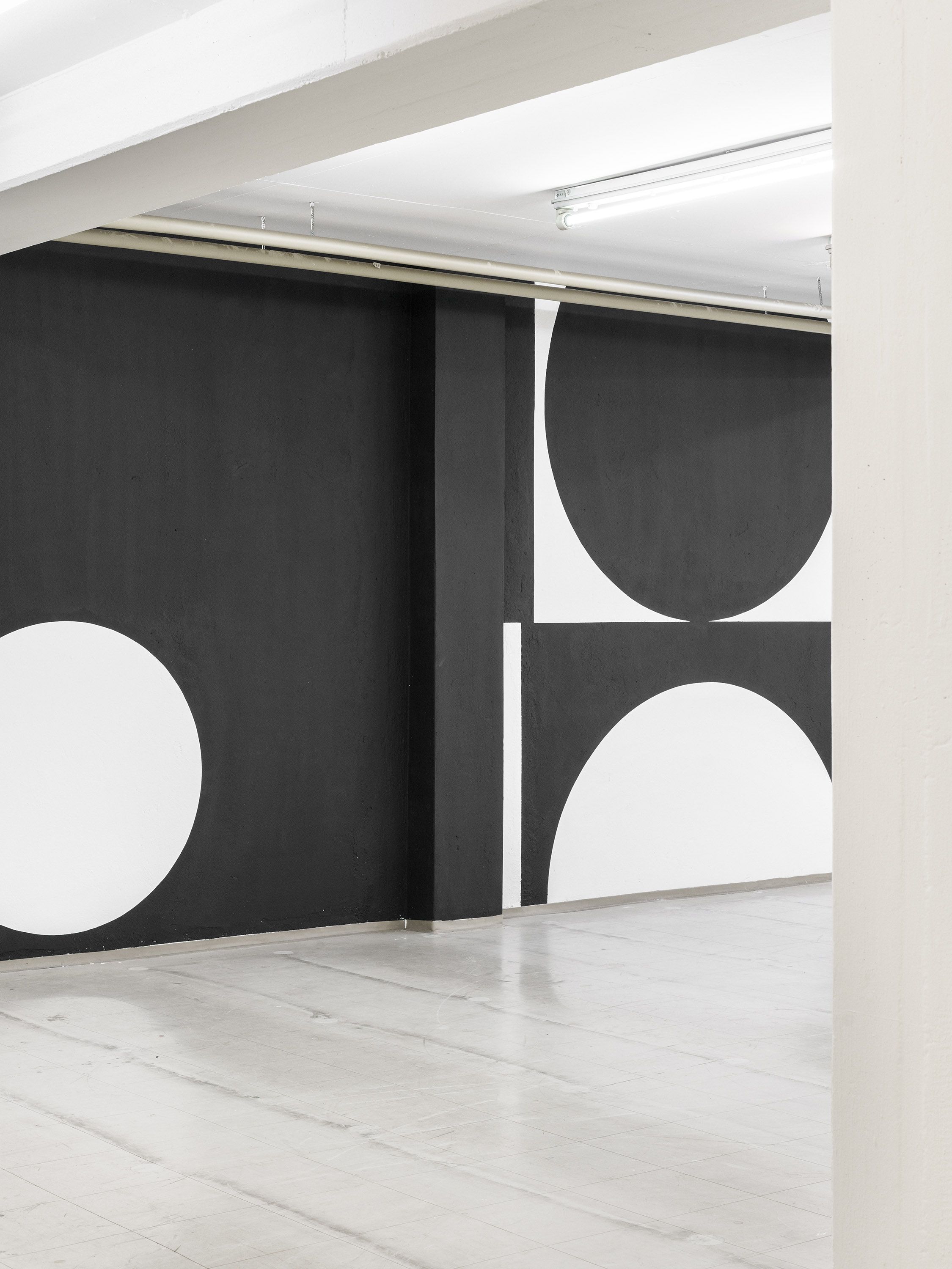 Solo exhibition wall graphic by Manuel Lorenz, black geometric shapes on white wall