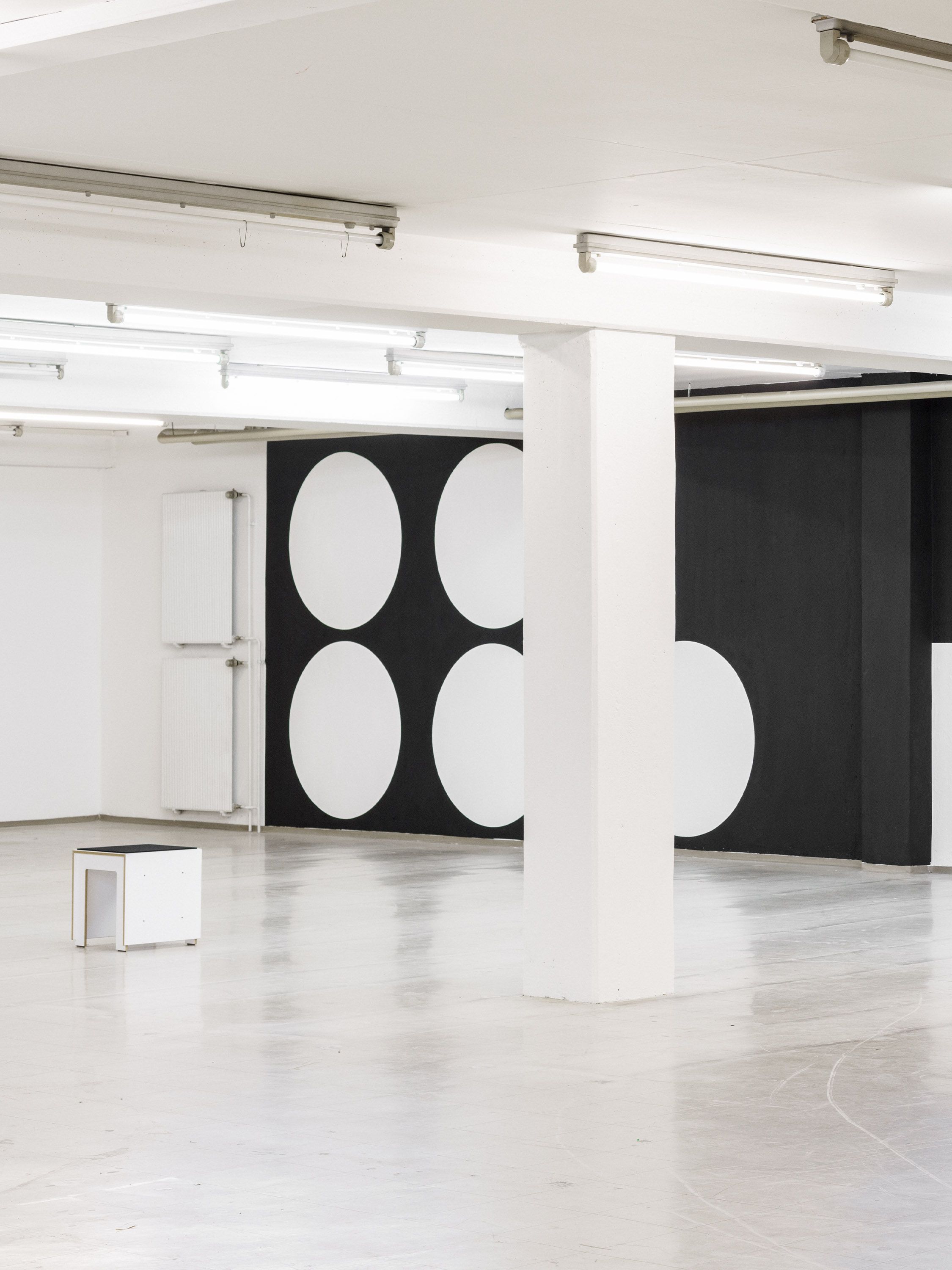Solo exhibition wall graphic by Manuel Lorenz, black geometric shapes on white wall
